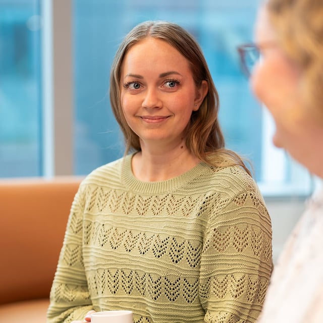 Tre kvinnor dricker kaffe.