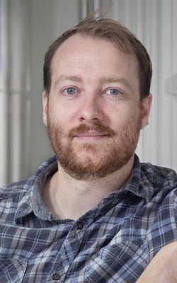 A man with a beard and blue shirt.