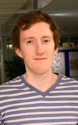 A young man with dark hair and a striped t-shirt.